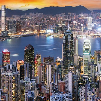 Wallpaper rotund cu o vedere nocturnă asupra orașului Hong Kong, cu lumini strălucitoare, zgârie-nori impunători și un cer colorat.