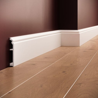 Plintă decorativă albă din polimer rigid montată la baza unui perete vopsit într-o nuanță închisă.